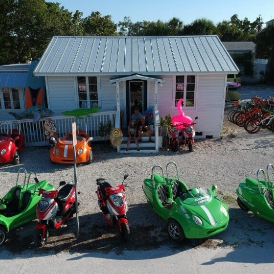 buggies and scooters in front of a beach shack